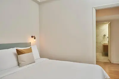 a bedroom with a white bed and a bathroom at Chic n Bright 3Bd Apt with Hilton View in Athens
