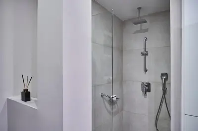 a bathroom with a shower with a glass door at Chic n Bright 3Bd Apt with Hilton View in Athens