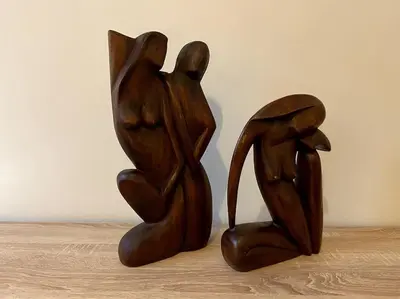 two wooden sculptures of two people sitting on a table at Cozy and comfortable apartment in Athens Center in Athens