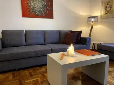a living room with a blue couch and a table at Cozy and comfortable apartment in Athens Center in Athens