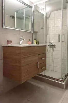 a bathroom with a sink and a shower with a mirror at Cozy and comfortable apartment in Athens Center in Athens