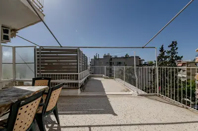 a balcony with a table and chairs and a fence at Alimos Marina Sunnyhub in Athens
