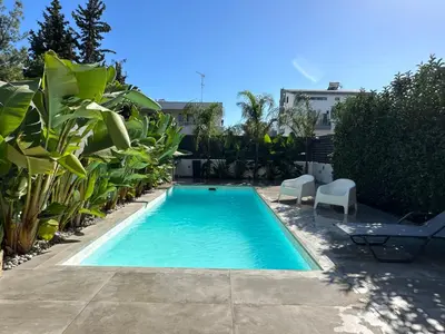 a small swimming pool with chairs and plants at Pool Voula Apartment close to Kavouri Beach by Cielo Homes in Athens
