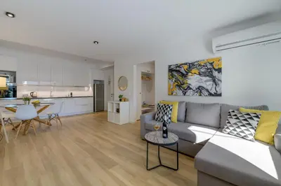a living room with a couch and a table and a kitchen at Pool Voula Apartment close to Kavouri Beach by Cielo Homes in Athens