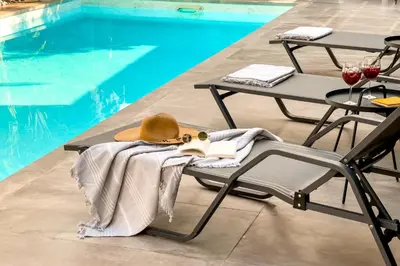 a hat and a towel on a chair next to a pool at Pool Voula Apartment close to Kavouri Beach by Cielo Homes in Athens
