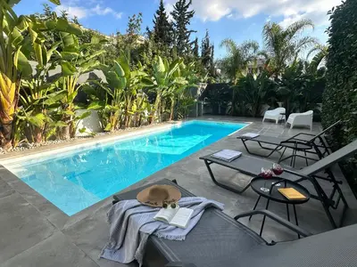 a swimming pool with a table and chairs next to it at Pool Voula Apartment close to Kavouri Beach by Cielo Homes in Athens