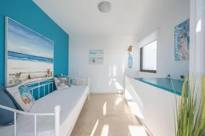 a room with a bed and a blue wall at Adelos Maisonette Near Vouliagmeni Beach in Athens