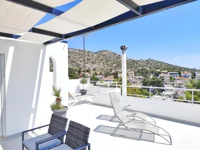 a balcony with chairs and a view of a city at Adelos Maisonette Near Vouliagmeni Beach in Athens