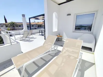 a balcony with two chairs and a table at Adelos Maisonette Near Vouliagmeni Beach in Athens