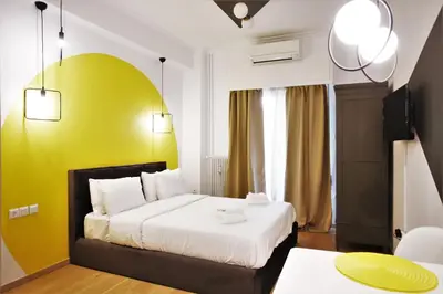 a hotel room with a bed and a yellow wall at GK Aria by GK Properties in Athens