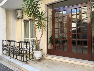 a palm tree in a pot next to a door at GK Aria by GK Properties in Athens