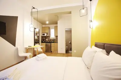 a bedroom with a large bed and a kitchen at GK Aria by GK Properties in Athens
