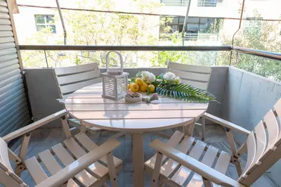 a table with fruit and flowers on a balcony at Chalandri Sweet House in Athens