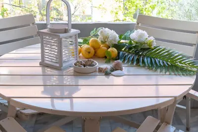 a white table with fruits and flowers on it at Chalandri Sweet House in Athens