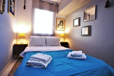 a bedroom with a blue bed with towels on it at Vintage Apartment in Athens