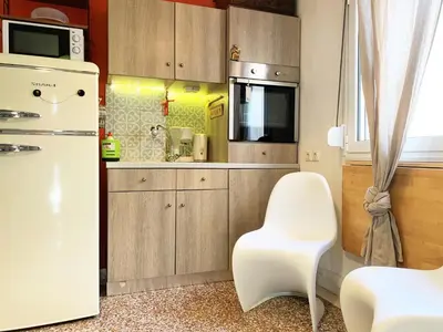 a kitchen with a white refrigerator and a white chair at Vintage Apartment in Athens