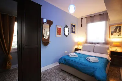 a bedroom with a bed with blue walls and a window at Vintage Apartment in Athens