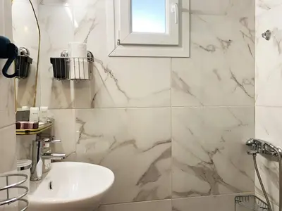 a white bathroom with a sink and a mirror at Vintage Apartment in Athens