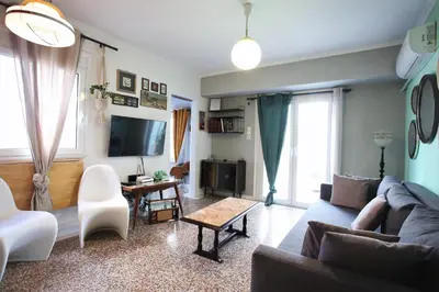 a living room with a couch and a tv at Vintage Apartment in Athens