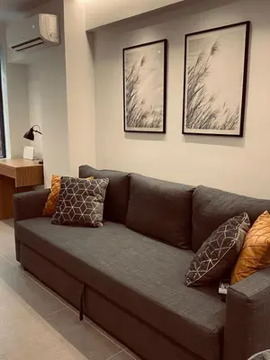 a brown couch in a living room with pictures on the wall at Small Meisonette Near The Metro VIPGreece in Athens