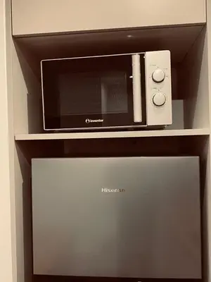 a microwave oven sitting on top of a shelf at Small Meisonette Near The Metro VIPGreece in Athens