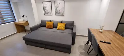 a living room with a bed and a wooden table at Small Meisonette Near The Metro VIPGreece in Athens