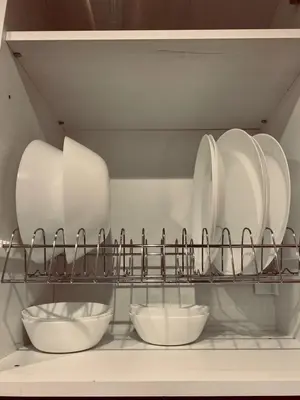 a shelf with white plates and bowls on it at Small Meisonette Near The Metro VIPGreece in Athens