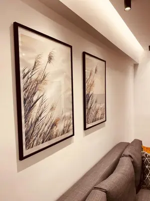 two framed pictures on a wall next to a couch at Small Meisonette Near The Metro VIPGreece in Athens