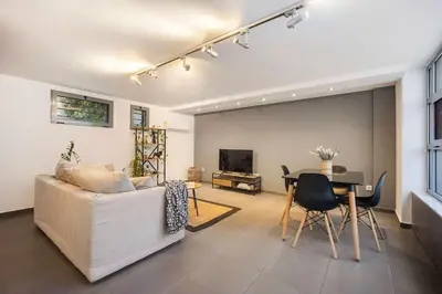 a living room with a couch and a table at Stylish 2BR Koukaki l Balcony & Work-Friendly Desk in Athens