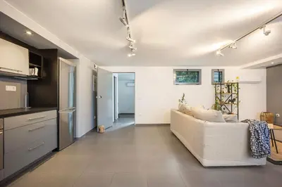 a living room with a couch and a kitchen at Stylish 2BR Koukaki l Balcony & Work-Friendly Desk in Athens