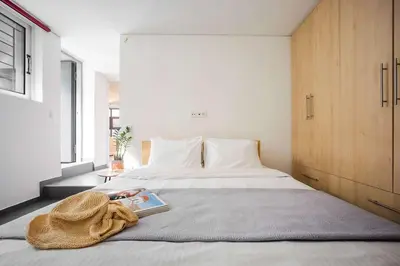 a bedroom with a bed with a book on it at Stylish 2BR Koukaki l Balcony & Work-Friendly Desk in Athens