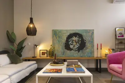 a living room with a painting of a monkey at Α Rare Lux Artistic RENV Gem opposite EMST Museum in Athens