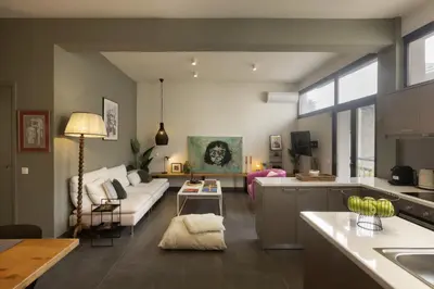 a kitchen and living room with a couch and a table at Α Rare Lux Artistic RENV Gem opposite EMST Museum in Athens