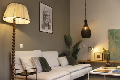 a living room with a white couch and a lamp at Α Rare Lux Artistic RENV Gem opposite EMST Museum in Athens