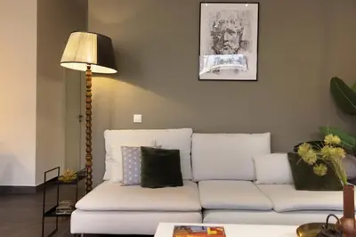 a living room with a white couch and a lamp at Α Rare Lux Artistic RENV Gem opposite EMST Museum in Athens