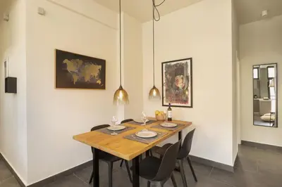 a dining room with a wooden table and chairs at Α Rare Lux Artistic RENV Gem opposite EMST Museum in Athens