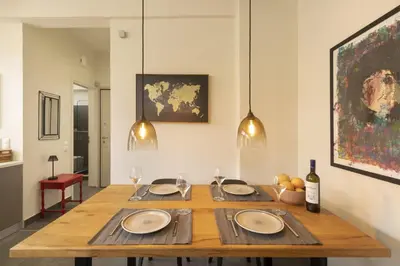 a dining room table with plates and wine glasses at Α Rare Lux Artistic RENV Gem opposite EMST Museum in Athens