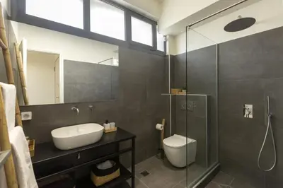 a bathroom with a sink and a toilet and a shower at Α Rare Lux Artistic RENV Gem opposite EMST Museum in Athens