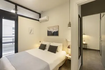 a bedroom with a large white bed and a window at Α Rare Lux Artistic RENV Gem opposite EMST Museum in Athens