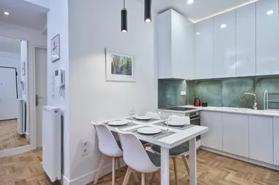 a white kitchen with a white table and chairs at Elite Living 2bd Apt next to Hilton-Ilisia Park in Athens
