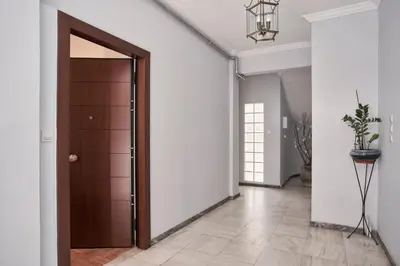 a hallway with a wooden door and white walls at Elite Living 2bd Apt next to Hilton-Ilisia Park in Athens