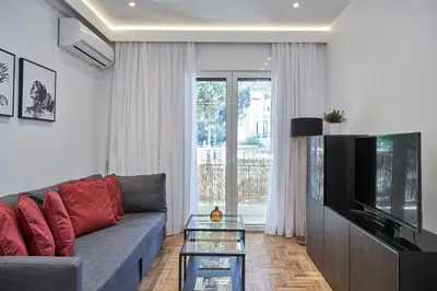 a living room with a couch and a tv at Elite Living 2bd Apt next to Hilton-Ilisia Park in Athens