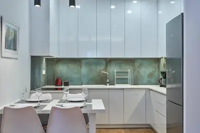 a kitchen with white cabinets and a table and chairs at Elite Living 2bd Apt next to Hilton-Ilisia Park in Athens