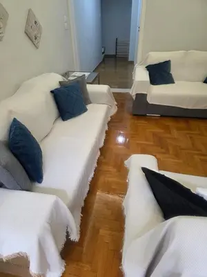 a living room with two white couches and blue pillows at Acropolis Select Flat in Athens