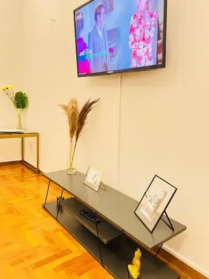 a living room with a table with a tv on the wall at Acropolis Select Flat in Athens