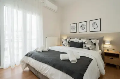 a bedroom with a large bed with two pillows on it at The Athens Gathering, Hip area and sightseeing in Athens