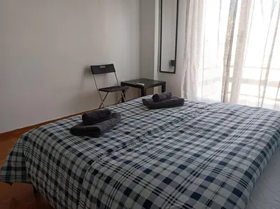 a bedroom with a bed with two pillows on it at Rooms in the apartment (Leontiou) in Athens