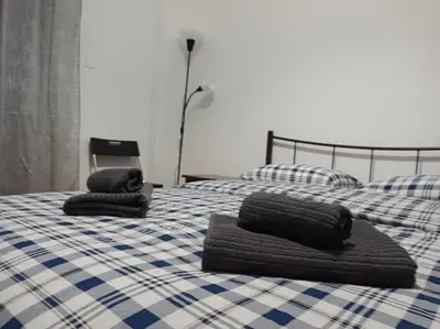 two beds with towels sitting on top of them at Rooms in the apartment (Leontiou) in Athens