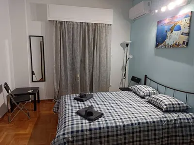 a bedroom with a bed and a desk and a window at Rooms in the apartment (Leontiou) in Athens