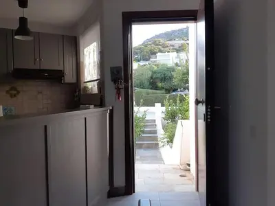 a kitchen with an open door leading to a balcony at Breezy summer maisonette with exciting view! in Aghia Marina